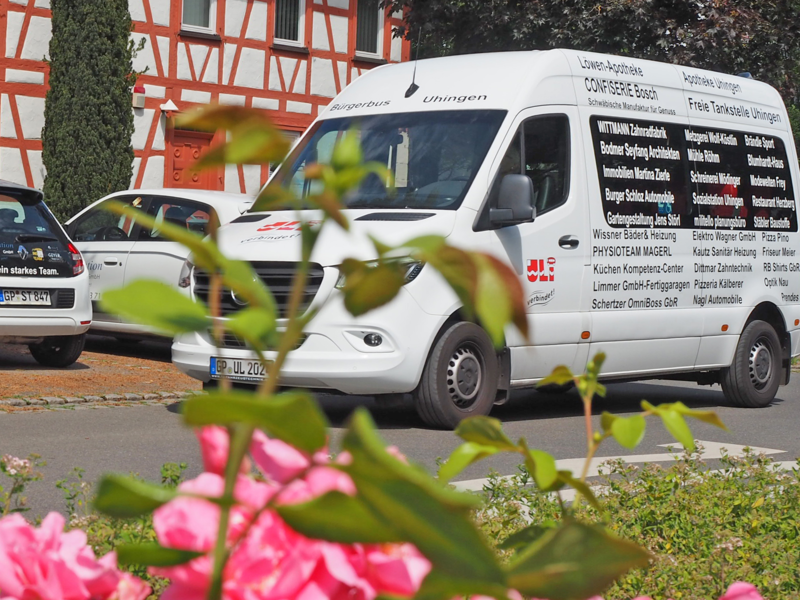 Der Bürgerbus Uli-Bus fährt über die Filsbrücke der Sparwieser Straße, im Hintergrund ist ein Fachwerkhaus zu sehen.
