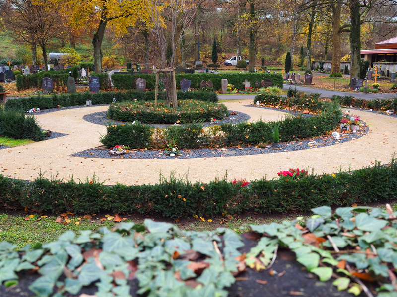 Auf dem Uhinger Friedhof gibt es eine Urnengrabanlage: Die Urnen befinden sich an einem geschwungenen Weg, dazwischen sind Bäume gepflanzt.