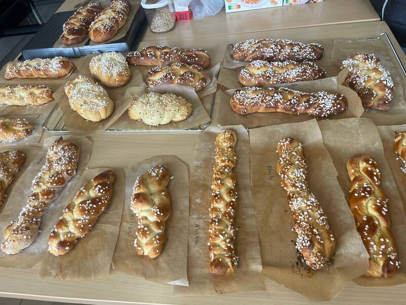 Auf einem Tisch in der Lehrerküche der Grundschule in Sparwiesen liegen zahlreiche frisch gebackene Hefezöpfe, die mit Hagelzucker bestreut sind.