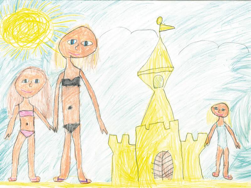 Am Strand stehen zwei Mädchen in Bikinis neben einer Sandburg, auf der anderen Seite der Sandburg steht ein Mädchen im Badeanzug.